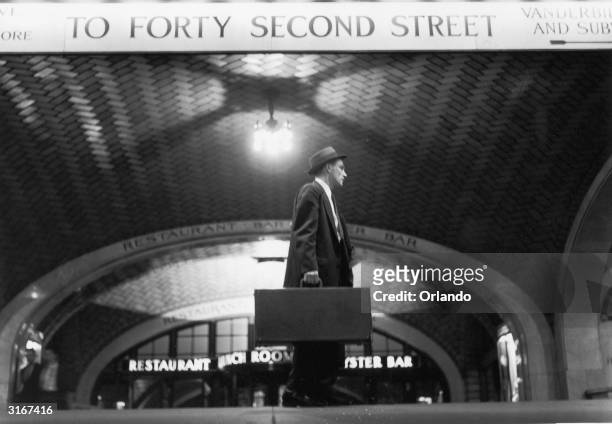 Salesman arriving at Grand Central Station, New York, makes his way towards 42nd Street.