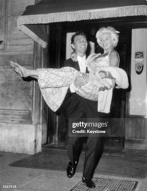 Glamorous American film star Jayne Mansfield, in Rome for the filming of George Sherman's 'Panic Button', leaves a night club with her husband Mickey...