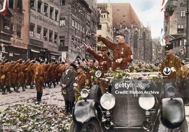 Austrian born German fascist dictator, Adolf Hitler, saluting the massed ranks of his party during the party congress at Nuremberg.