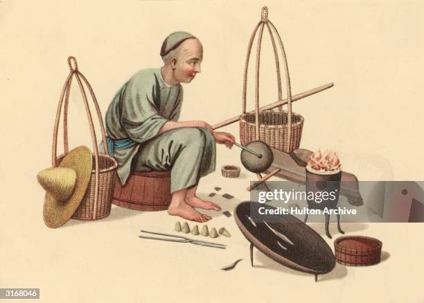 Chinese man surrounded by the tools with which he repairs pots, cauldrons and kettles.