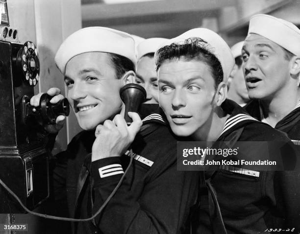 Frank Sinatra as Clarence Doolittle in MGM's 'Anchors Aweigh', directed by George Sidney. He and the other sailors eavesdrop on shipmate Gene Kelly...