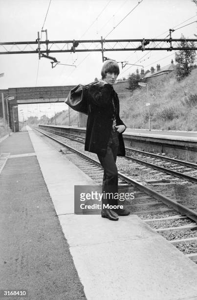 Radio Caroline disc jockey Johnnie Walker waiting at a railway station.
