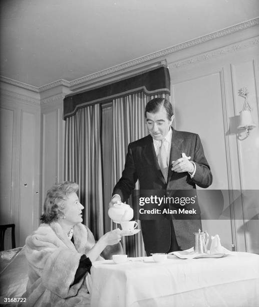 English actor Robert Newton at home pouring tea for his fourth wife, Vera Budnick.