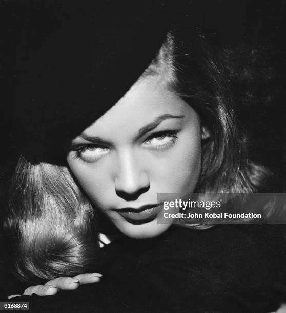 American screen star Lauren Bacall glowers over her shoulder.