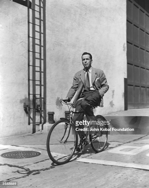 American actor Humphrey Bogart on a bicycle.