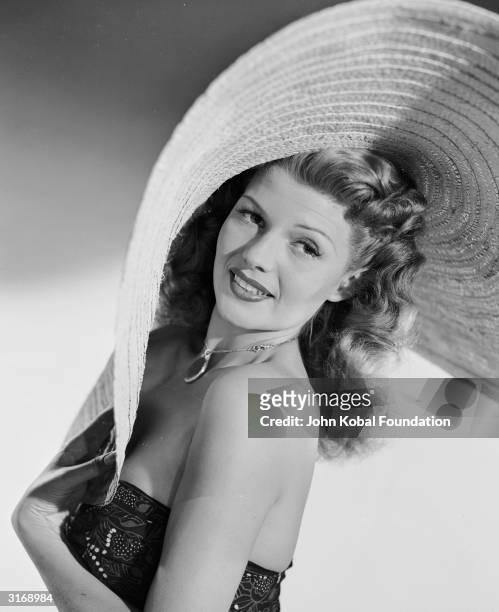 American film actress, dancer and singer Rita Hayworth wearing a giant sombrero.