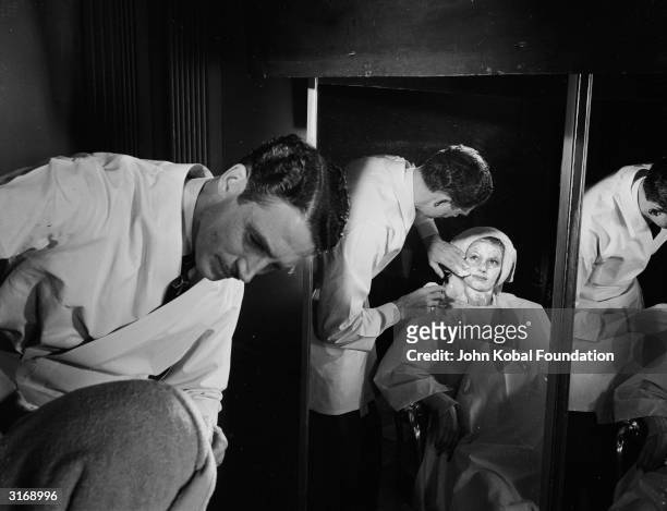 American film actress, dancer and singer Rita Hayworth undergoing a facial treatment in a scene from the comedy musical 'Cover Girl', directed by...