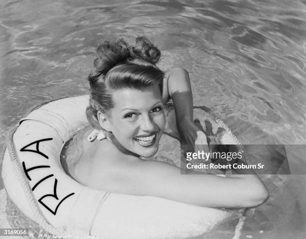 American film actress, dancer and singer Rita Hayworth floating in her own life ring.