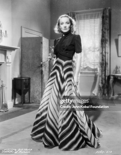 Paramount film star Marlene Dietrich in a tailored dress with a long skirt in a geometric pattern.