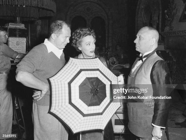 From left to right, director Billy Wilder with actors Gloria Swanson and Erich von Stroheim on the set of the showbiz satire 'Sunset Boulevard'.