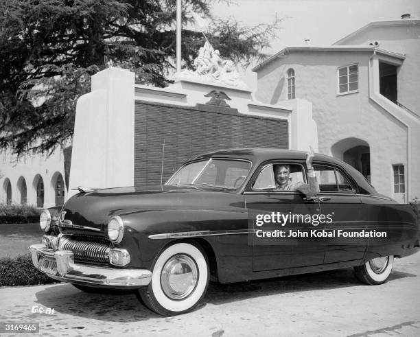 Gary Cooper , American leading man and long-enduring Hollywood star, in his 1949 Mercury Sedan with white walled tyres.