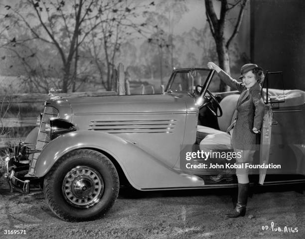 Actress Olivia Mary de Havilland standing next to her car. She was attached to Warner Brothers for most of her acting career until she sued them in...