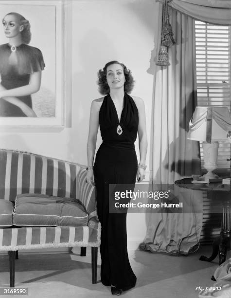 American actress Joan Crawford as she appeared in Edward H Griffith's 'No More Ladies', wearing a gown by Adrian.