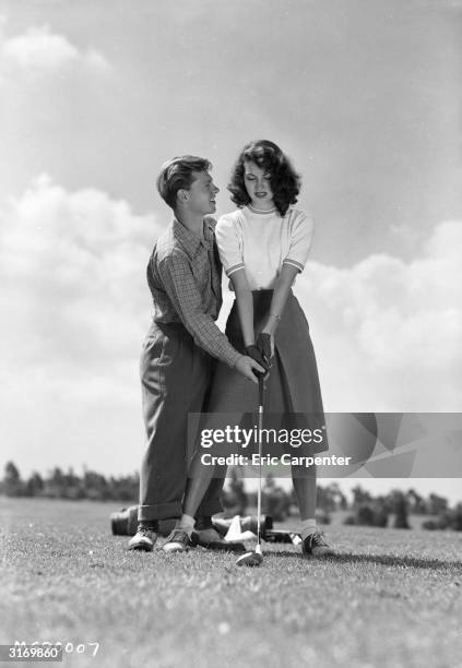 Actress Ava Gardner takes a golfing tip from her husband, former child actor Mickey Rooney.
