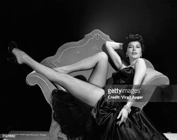 American actress Ava Gardner shows off her famous legs in a pair of fishnet stockings.