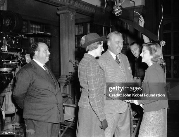 British director Alfred Hitchcock watching actors Gladys Cooper , Nigel Bruce and Joan Fontaine on the set of his latest thriller 'Rebecca'.