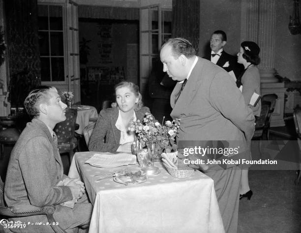 British director Alfred Hitchcock stops to talk to Laurence Olivier and Joan Fontaine, the stars of his latest thriller 'Rebecca'.