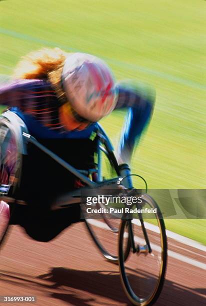 paraplegic athlete using racing wheelchair (blurred motion) - carrera de sillas de ruedas fotografías e imágenes de stock