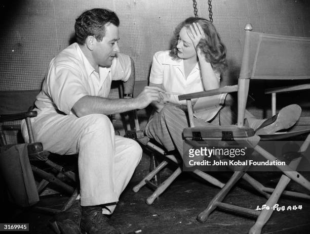 Hollywood director William Wyler on the set of 'The Little Foxes' with actress Bette Davis .