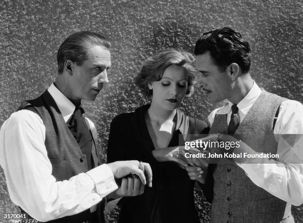 From left to right, Lars Hanson , Greta Garbo and John Gilbert examine each others' rings on the set of 'Flesh and the Devil', directed by Clarence...