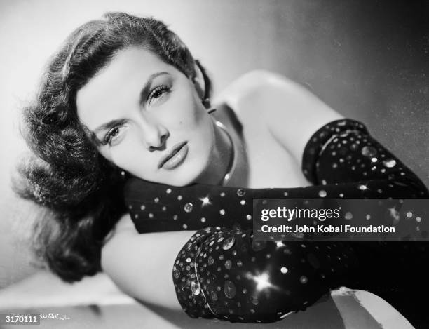 American actress Jane Russell wearing long black gloves studded with sequins.