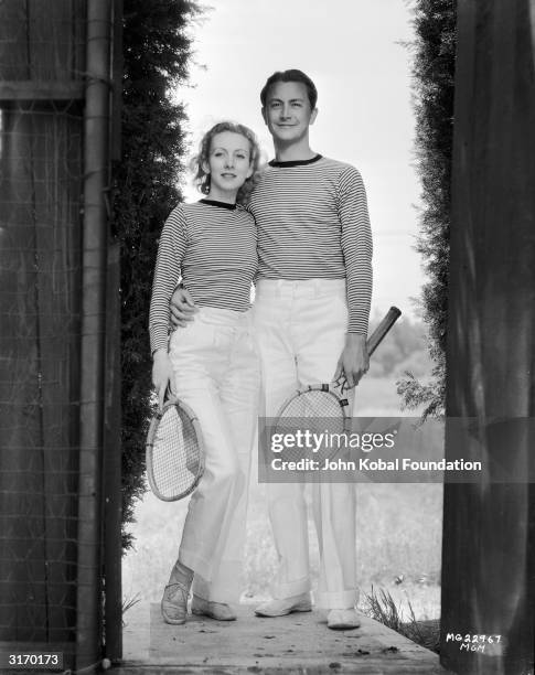 American actor Robert Young with his girlfriend, actress Karen Morley, in their matching tennis outfits.