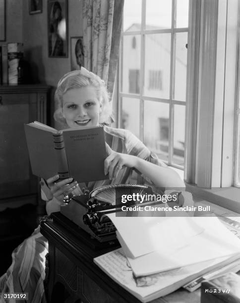 Actress Jean Harlow studies the novel 'Red Headed Woman' witten by Katherine Brush, on which the film of the same name was based. Harlow took the...