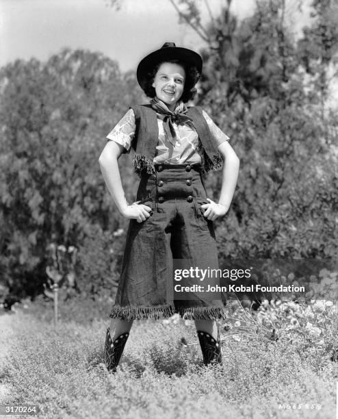 Singing film star Judy Garland wearing a western-style costume.