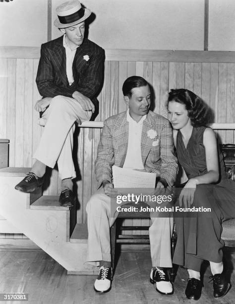 Composer Cole Porter discusses his musical score with dancers Fred Astaire and Eleanor Powell on the set of 'Broadway Melody of 1940', directed by...