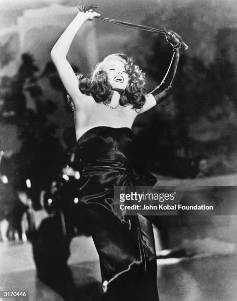 Rita Hayworth performs her famous erotic dance in the wartime film noir 'Gilda', directed by Charles Vidor.