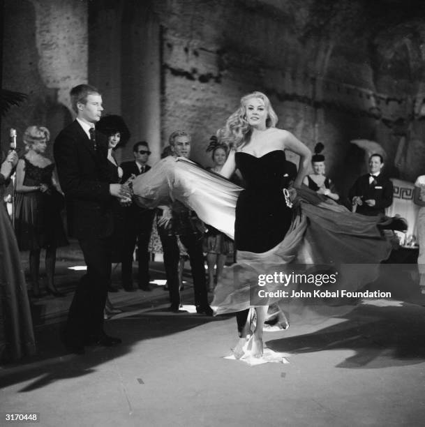 Swedish actress Anita Ekberg gets carried away by the music at a jazz club in a scene from 'La Dolce Vita', directed by Federico Fellini.