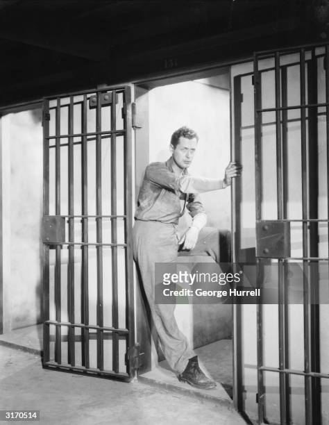 American actor Robert Montgomery stars as imprisoned playboy Kent Marlowe in 'The Big House', a prison drama directed by George Hill.
