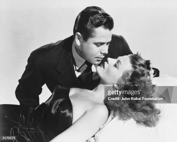 Glenn Ford succumbs to the considerable charms of Rita Hayworth in the wartime film noir 'Gilda', directed by Charles Vidor.
