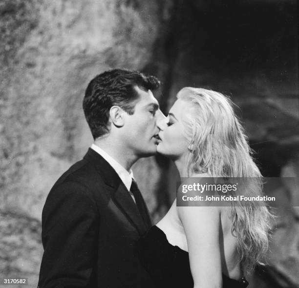 Marcello Mastroianni and Anita Ekberg share a screen kiss in 'La Dolce Vita', directed by Federico Fellini.