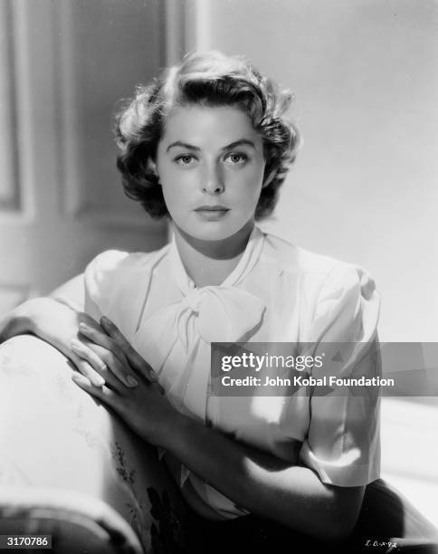 Film star Ingrid Bergman wearing a short sleeved blouse with a pussy-cat bow neckline.