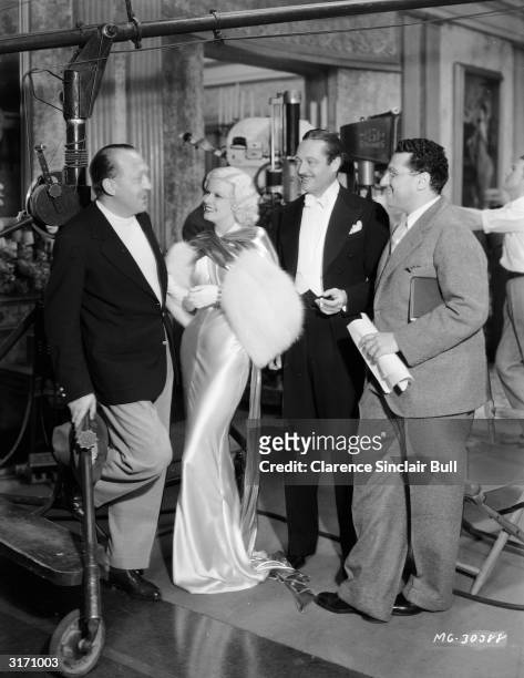 'Blonde Bombshell' Jean Harlow chats to British film director Edmund Goulding , who is visiting the set of the MGM film 'Dinner at Eight'. Actor...