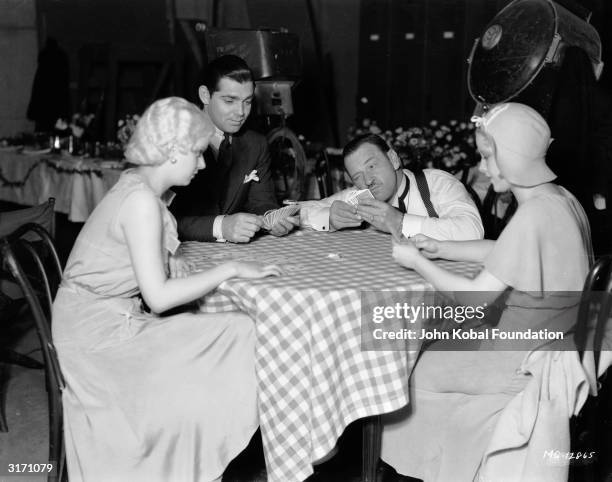 Left to right : Jean Harlow , Clark Gable , Paul Hurst and Mary Carlisle playing cards in a scene from 'The Secret Six', directed by George W Hill.