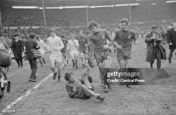 Chelsea's Ian Hutchinson looks down in sympathy as his team mate, full back Eddie McCreadie collapses with cramp after the FA Cup final. The final...