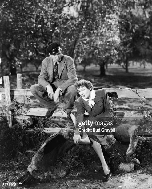 French actress Claudette Colbert complains of sore feet in a scene from W S Van Dyke's screwball comedy 'It's a Wonderful World', while her co-star...