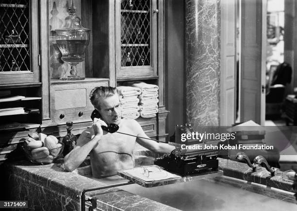 In a scene from the 20th Century Fox film noir, 'Laura', directed by Otto Preminger, Clifton Webb, playing the character Waldo Lydecker, takes a...