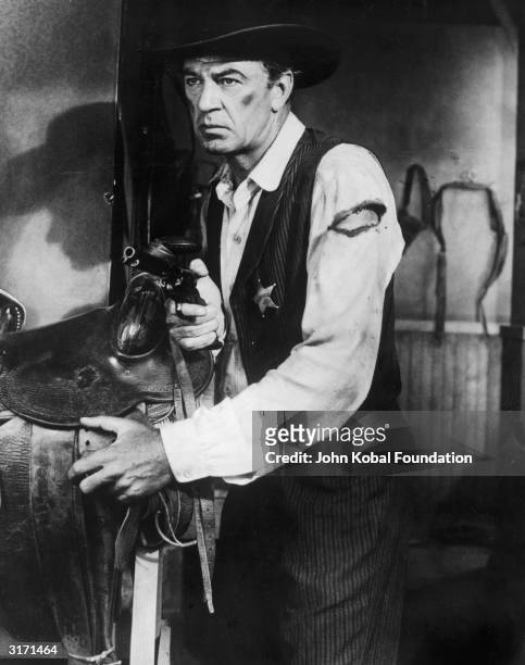 American actor Gary Cooper , as the sheriff Will Kane in Fred Zinnemann's 'High Noon', hides out in the stables.