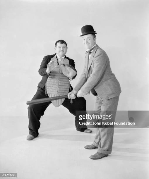 Stan Laurel stands ready to bat while Oliver Hardy waits behind him with his catcher's mitt and body padding.