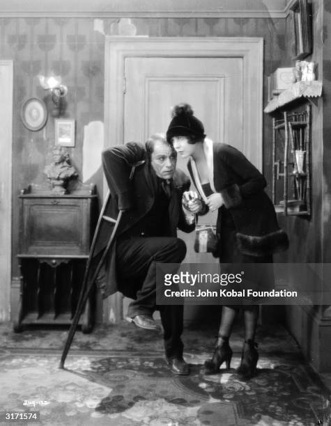 American actor Lon Chaney masquerades as a cripple in the presence of Renee Adoree in a scene from 'The Blackbird', directed by Tod Browning.