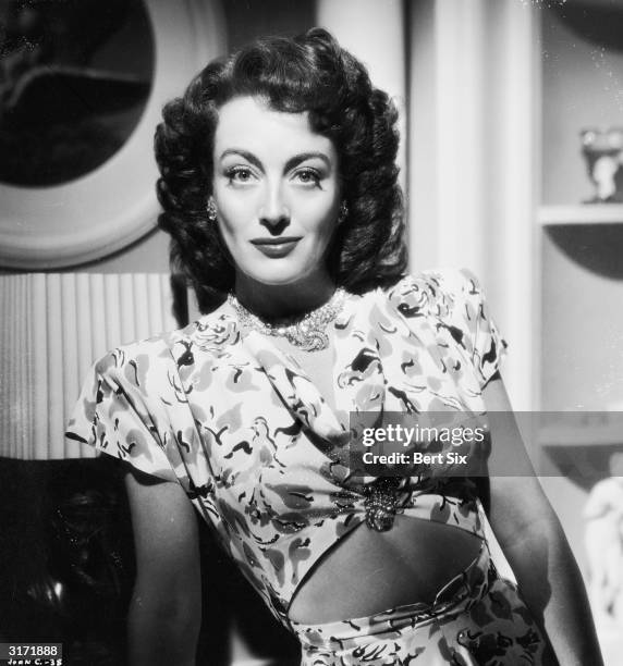 American film actress Joan Crawford wearing a patterned blouse worn high to expose her midriff at the time of her starring role in 'Mildred Pierce',...