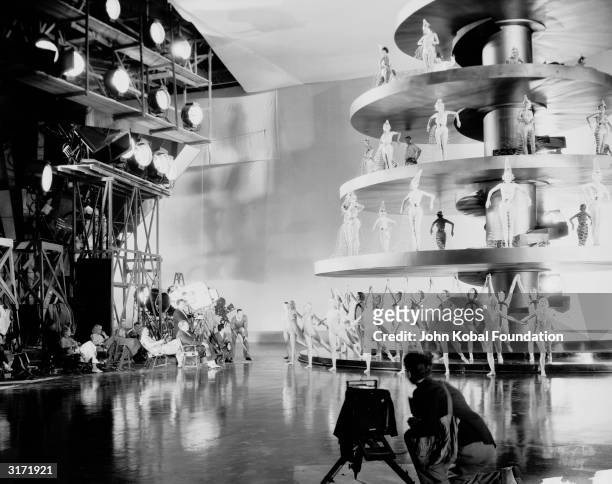 Equipped with a megaphone, director Robert Z Leonard supervises a dance scene on a huge tiered stage, during the filming of 'Dancing Lady'....