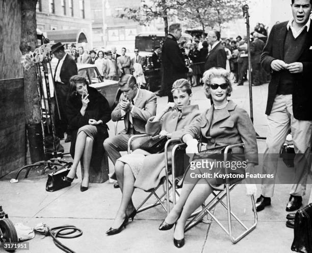 Actors take a break on a New York Street, during location filming for 'Breakfast At Tiffany's', directed by Blake Edwards. Centre left is leading...