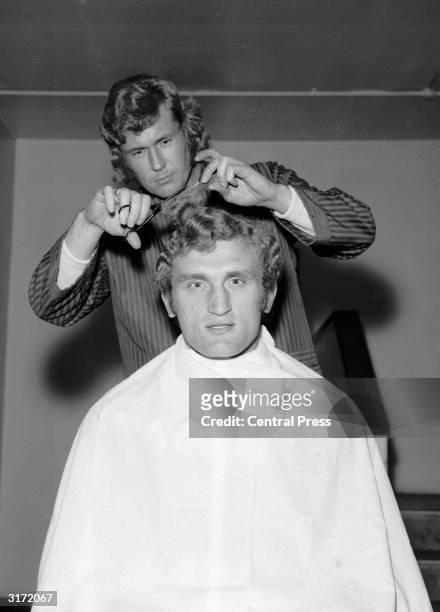 British boxer Joe Bugner gets a pre-match trim from hairdresser Ray King prior to his fight against Argentina's Eduardo Corletti, allegedly the...