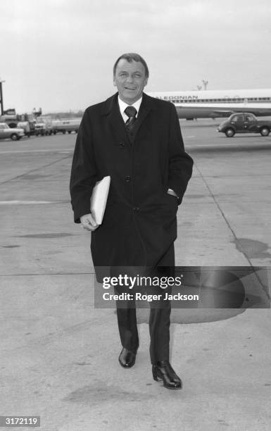 Frank Sinatra arrives at Gatwick airport to attend a charity concert alongside Bob Hope at the Royal Festival Hall.