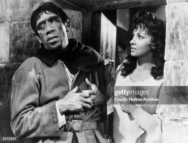 Mexican-born actor Anthony Quinn in costume as Quasimodo and Italian-born actor Gina Lollobrigida as Esmerelda in a still from director Jean...