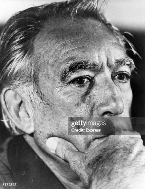 Close-up portrait of Mexican-born actor Anthony Quinn holding his chin with his hand.